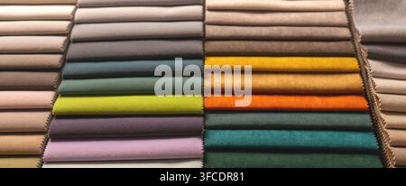 Colorful fabric swatches arranged in rows for upholstery. Textile samples showing various colors and textures for interior design. Curtain and furnitu Stock Photo