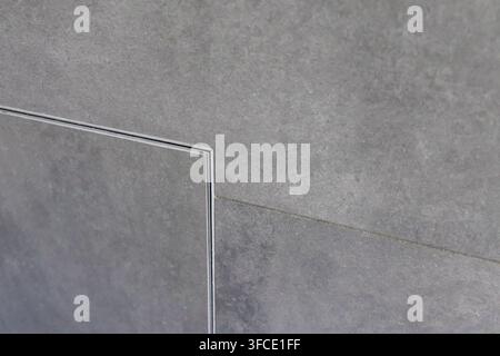 A close-up view of a textured gray concrete surface featuring a subtle linear joint and a recessed panel detail Stock Photo