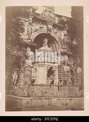 Two men leaning over the balustrade in the Villa d'Este in Tivoli, Italy, Villa d'Este, Tivoli, photograph, number: '20A', inscription: 'K', inscription: 'L'Organo', 1851 - 1900, photographer, pasteboard, paper, albumen print, height 485 mm x width 322 mm, palace, Villa d'Este (Tivoli)., A detailed stone façade with ornate carvings and sculpted figures fills the image, featuring a domed architectural element topped by a small statue and flanked by an arched recess. Several sculpted human forms are integrated into the architecture, including reclining figures, standing statues and busts set Stock Photo