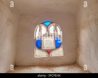 Sana'a, Yemen - 06 July 2023: Small old qamariah (stained glass) inside Dar Al Hajar (stone house), a royal palace on rock located in Wadi Dhahr. Stock Photo
