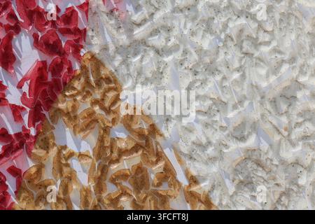 Macro Abstract Texture of Peeling Gold and Red Paint Chips Cracking on White Wall Surface Stock Photo