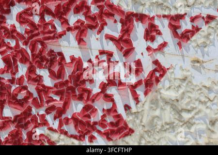 Macro Abstract Texture of Heavily Peeling and Flaking Red Paint on White Surface Stock Photo