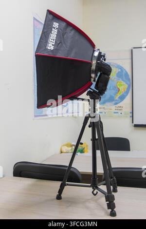 Professional studio lighting equipment setup for indoor photography, video recording, or streaming. Compact softbox with camera speedlight mounted on Stock Photo
