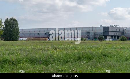 RIGA, LATVIA - AUGUST 25, 2026: Large logistics and warehouse complex with loading docks and trucks on the outskirts of Riga. Stock Photo