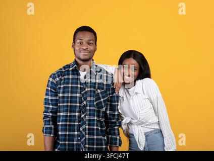 Happy relationship of student and fun together during covid-19 lockdown. Smiling young african american man and woman look at camera, lady put hand on Stock Photo