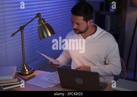 Writer working on his book in office at night Stock Photo