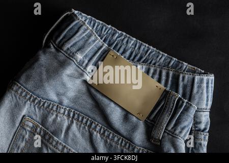 Light blue denim jeans fabric showing texture, stitching, waistband, and empty label Stock Photo