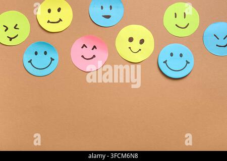 Sticky notes with smiley faces on brown background Stock Photo