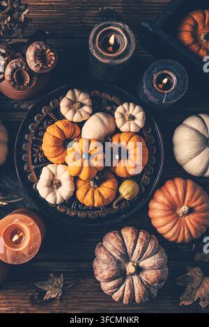 Autumn harvest bounty with glowing candles and rustic wooden table setting Stock Photo