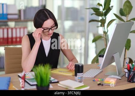 Focused businesswoman with glasses works with papers in office Stock Photo