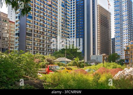 Batumi, Georgia - August 22, 2026: Modern high rise residential skyscrapers rise above small old houses and construction site showing resort city Stock Photo