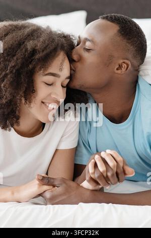 Close-up portrait of happy couple lying in bed together, enjoy each other company and free time Stock Photo