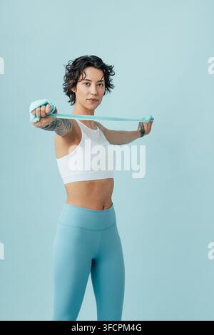 Woman practicing with a stretching band, doing arm exercises Stock Photo