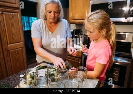 Grandmother and Granddaughter Making Homemade Pickles Together Stock Photo