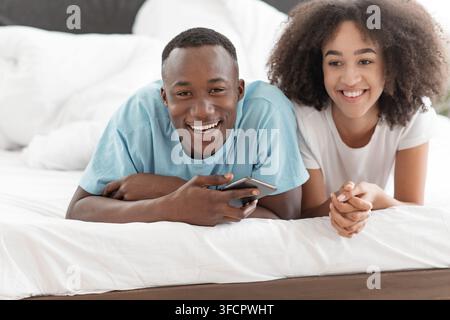 Cheerful romantic couple carefree young husband and wife enjoy weekend morning laughing, bonding, having fun at home Stock Photo