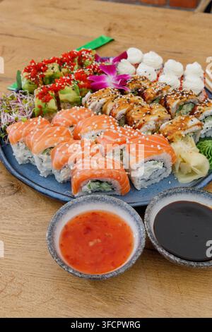 Delicious platter of assorted sushi rolls on a wooden table Stock Photo