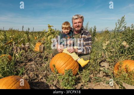 Family enjoying an autumn day in a pumpkin field Stock Photo