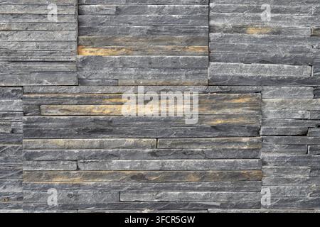 Close view of decorative stone cladding with irregular horizontal layers, suitable for interior walls, facades and architectural finishing. Stock Photo