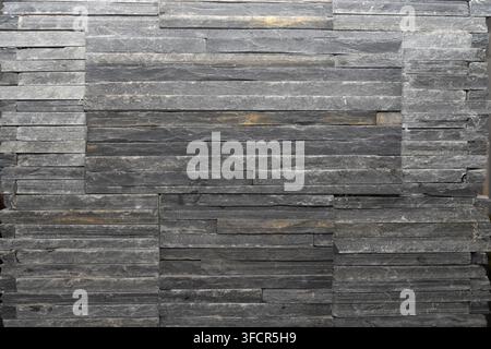 Close view of decorative stone cladding with irregular horizontal layers, suitable for interior walls, facades and architectural finishing. Stock Photo