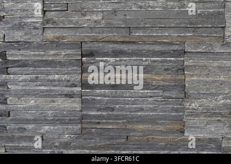Close view of decorative stone cladding with irregular horizontal layers, suitable for interior walls, facades and architectural finishing. Stock Photo