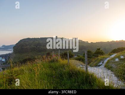 A fork in the path on the white cliffs of Dover looking to the castle and the harbour, Kent, England in the low evening sun Stock Photo