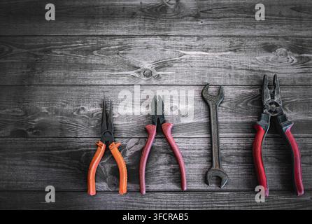 Set of Hand tools on a dark rustic wooden background, working tools, pliers and wrench. Photo of an old rusty tools on a wooden background top view Stock Photo