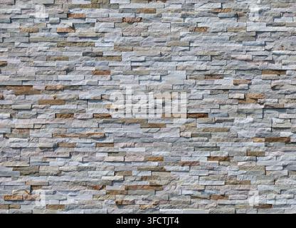 External wall coating made of stone bricks of different colors. Full frame. Background and texture. Stock Photo