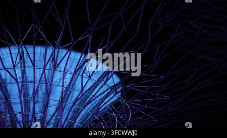Abstract geometric canopy structure lit blue at night.A close-up abstract view of an intersecting steel lattice canopy glowing blue against a dark nig Stock Photo