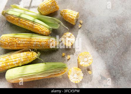 Yellow and white corn cobs with kernels arranged on a textured surface Stock Photo