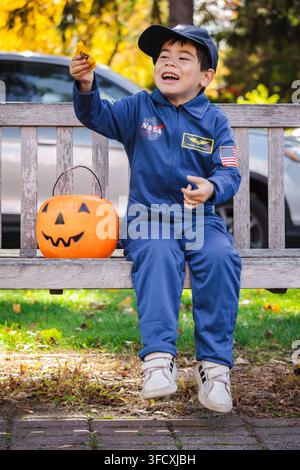 Boy in Astronaut Costume Holding Candy for Halloween Stock Photo