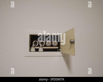 Vintage electrical fuse box on a white wall in a residential home, old-style circuit breaker panel Stock Photo