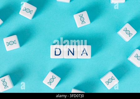 DNA text on blocks surrounded by blocks with helix symbols, representing genetics and biotechnology concepts Stock Photo