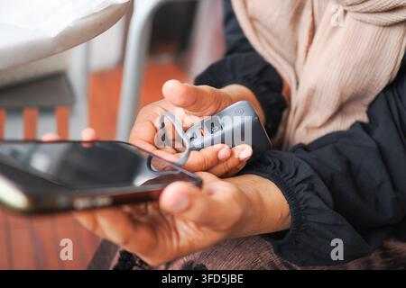 Person charging smart phone with power bank sitting on a cafe  Stock Photo