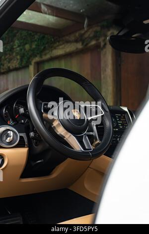 Interior View of a White Porsche Macan Steering Wheel and Beige Dashboard Stock Photo