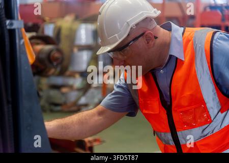 Professional worker pressing buttons on machine control board, technician operating machinist pressing emergency stop button on control panel in facto Stock Photo