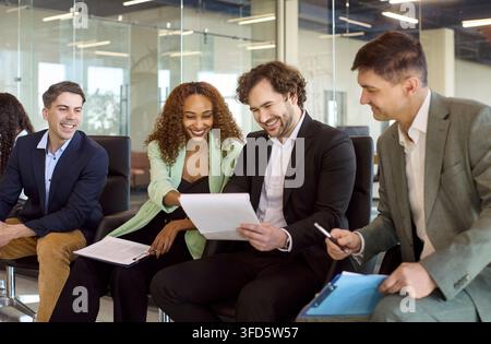 Diverse business team in office meeting reviewing documents and planning strategy Stock Photo