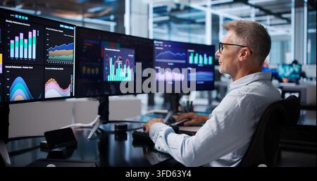 Financial Analyst Reviews Dashboard Data, Pointing To Market Trends Confidently. Stock Photo
