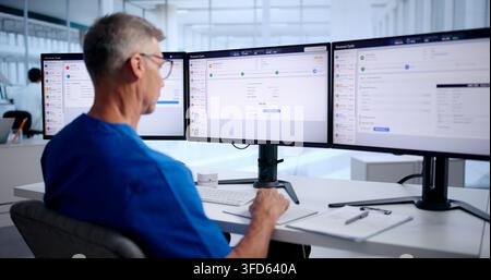 Medical Billing Manager Carefully Reviews Patient Insurance Claims On Computer. Stock Photo