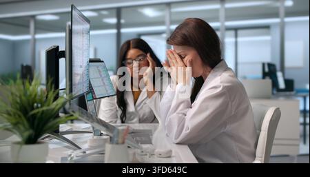 Tired Healthcare Worker Struggles With Migraine While Managing Billing Tasks. Stock Photo