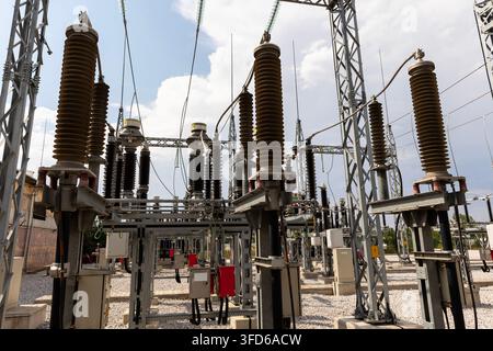 High-voltage electrical substation, featuring large porcelain or composite insulators mounted on steel support structures. Stock Photo