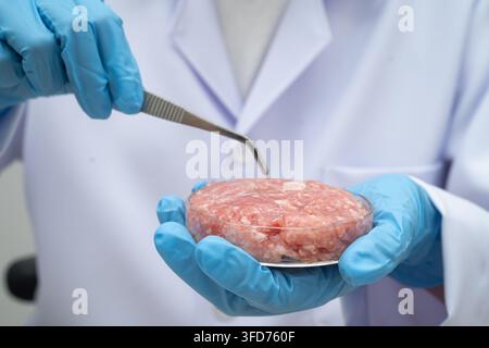 Scientist holding Petri dish with meat in science laboratory for food product development. Stock Photo
