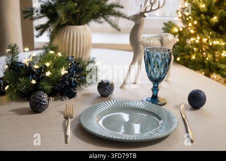 Christmas table setting with blue glass and silver reindeer Stock Photo