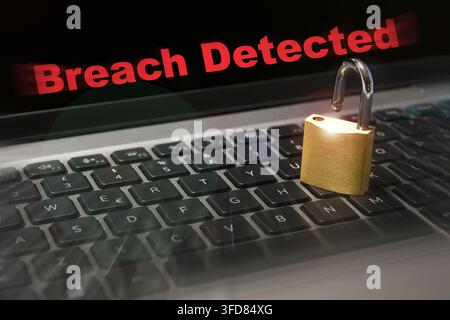 Computer security concept with an open padlock on the laptop keyboard and "Breach Detected" text on the screen. Cyber threat concept image. Stock Photo