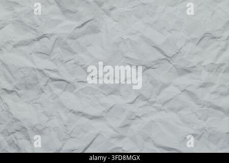 Crumpled white paper texture showing creases and wrinkles, providing an abstract background Stock Photo