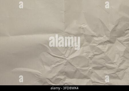 Crumpled beige paper showing abstract texture and intricate creases Stock Photo