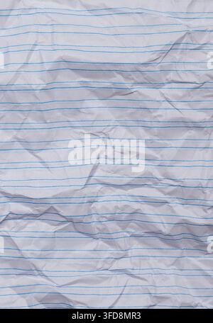 Crumpled white notebook paper showing blue lines and textured surface Stock Photo