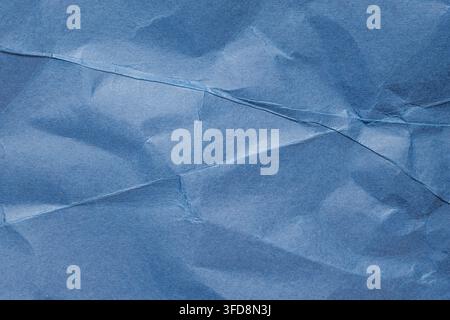 Blue crumpled paper showing creased and wrinkled texture for an abstract background Stock Photo
