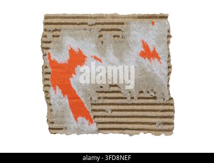 Torn corrugated cardboard scrap showcasing rough texture and orange paint splatters Stock Photo