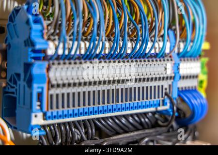 A detailed perspective of a densely wired electrical panel featuring multiple rows of terminal blocks and colorful insulated cables Stock Photo