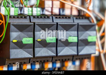 Close-up view of interconnected electronic modules featuring green status indicators and visible wiring, suggesting a complex system Stock Photo